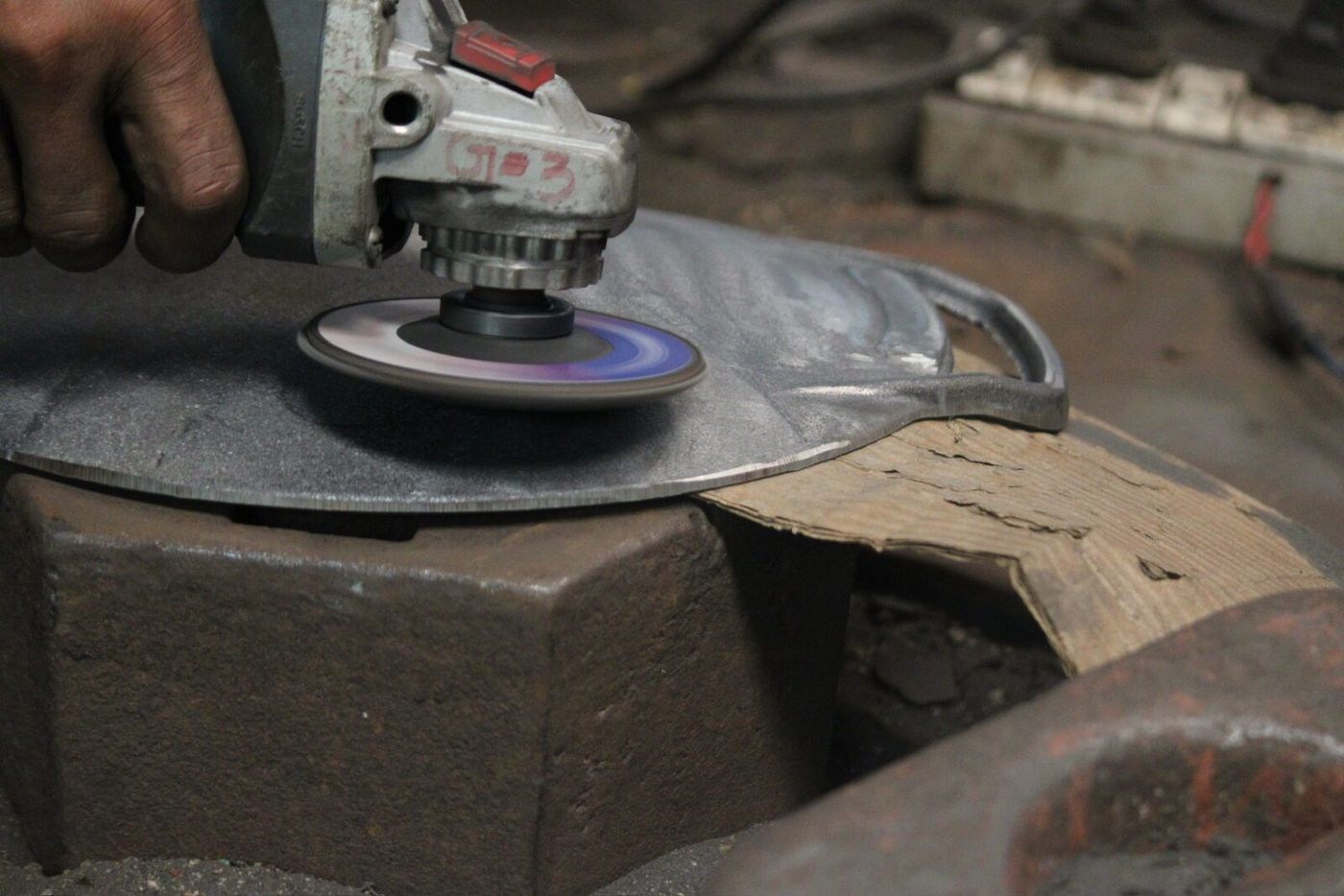 Angle grinder finishing a cast iron part